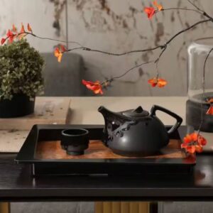 Elysian Stoneware Set featuring a sculptural black teapot and matching tea cups.
