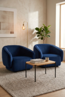 Two plush navy blue armchairs flank a modern coffee table in a well-lit room.