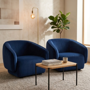 Two plush navy blue armchairs flank a modern coffee table in a well-lit room.